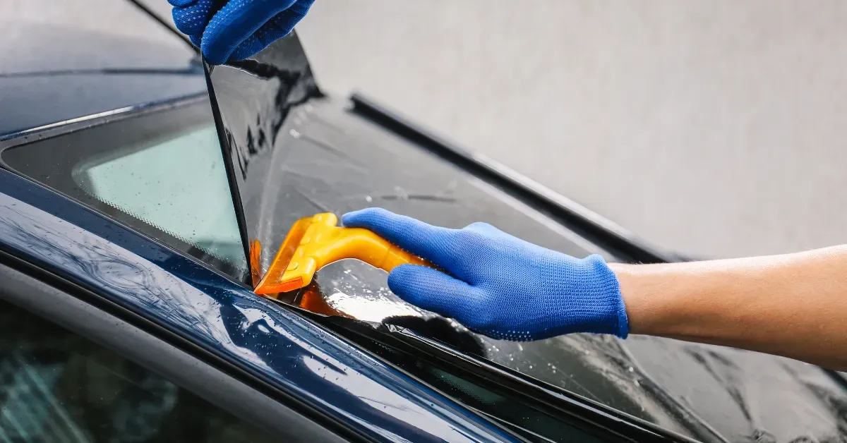 Professional Ottawa window tint installation: applying film bubble-free with squeegee