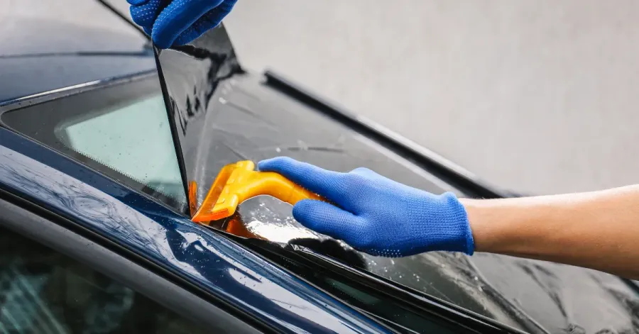 Professional Ottawa window tint installation: applying film bubble-free with squeegee