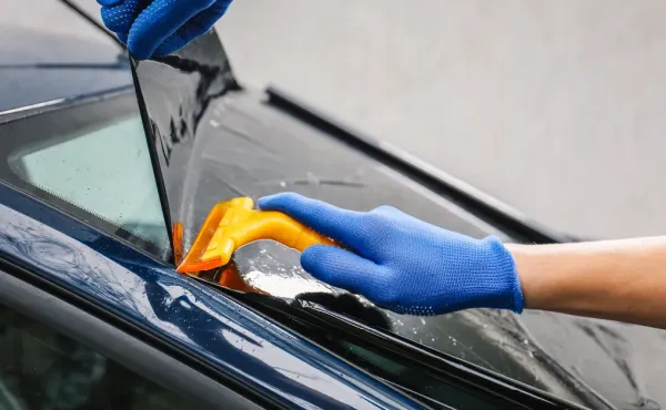 Professional Ottawa window tint installation: applying film bubble-free with squeegee